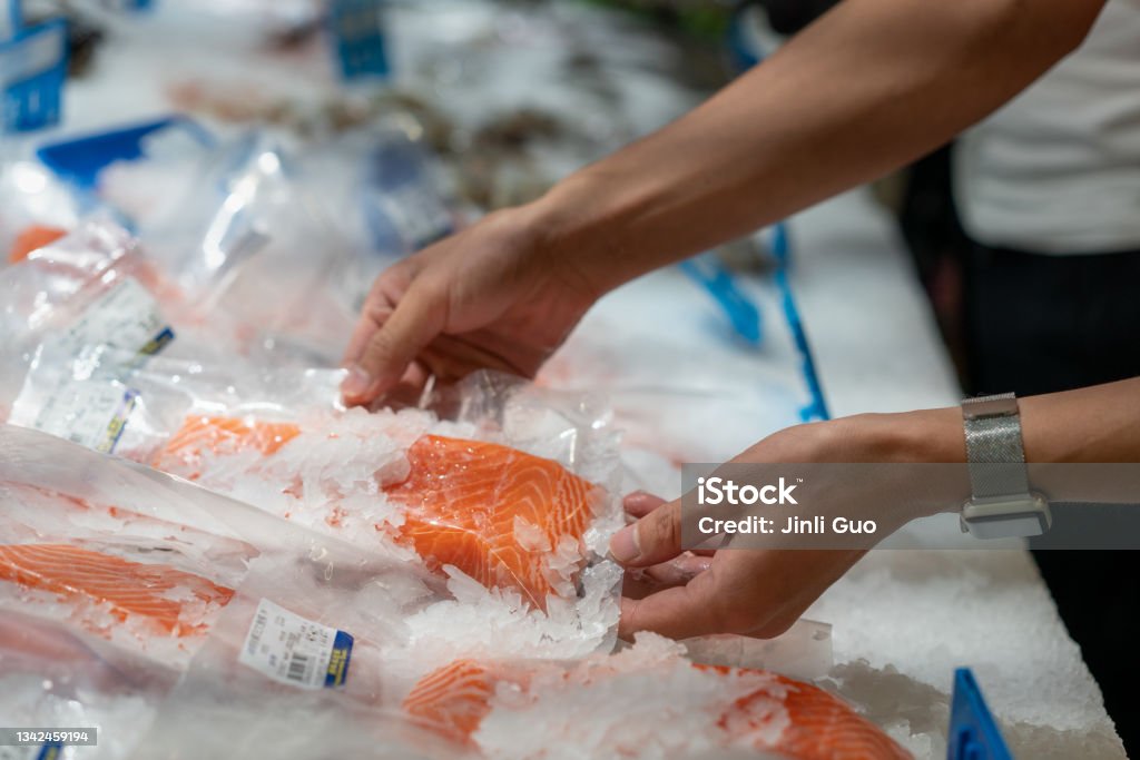 a-man-picks-salmon-in-the-supermarket