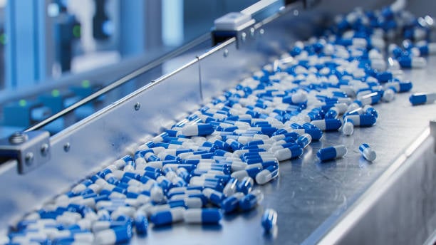 blue-capsules-on-conveyor-at-modern-pharmaceutical-factory-tablet-and-capsule-manufacturing